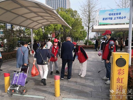 志愿服務隊在人民醫(yī)院路口開展文明交通體驗活動，并幫助老人提重物.jpg.jpg