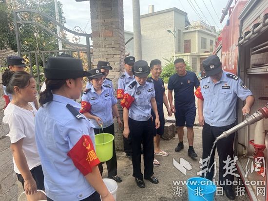 民輔警跟隨消防水車作業(yè)，通過肩挑手提的方式將清水送入行動不便的老年、殘障村民的家中（通訊員 李麗君 攝） (3).jpg.jpg